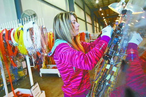 JENNIFER RUZZI WORKS ON A WIRE HARNESS TO BE USED IN A CASE BACKHOE AT COBO INTERNATIONAL'S PLANT IN BURLINGTON.